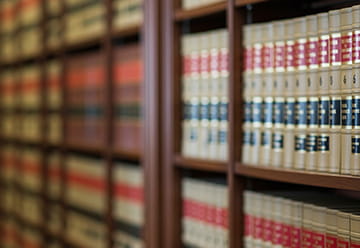 Bookshelves filled with law books, representing legal knowledge and resources relevant to immigration law.